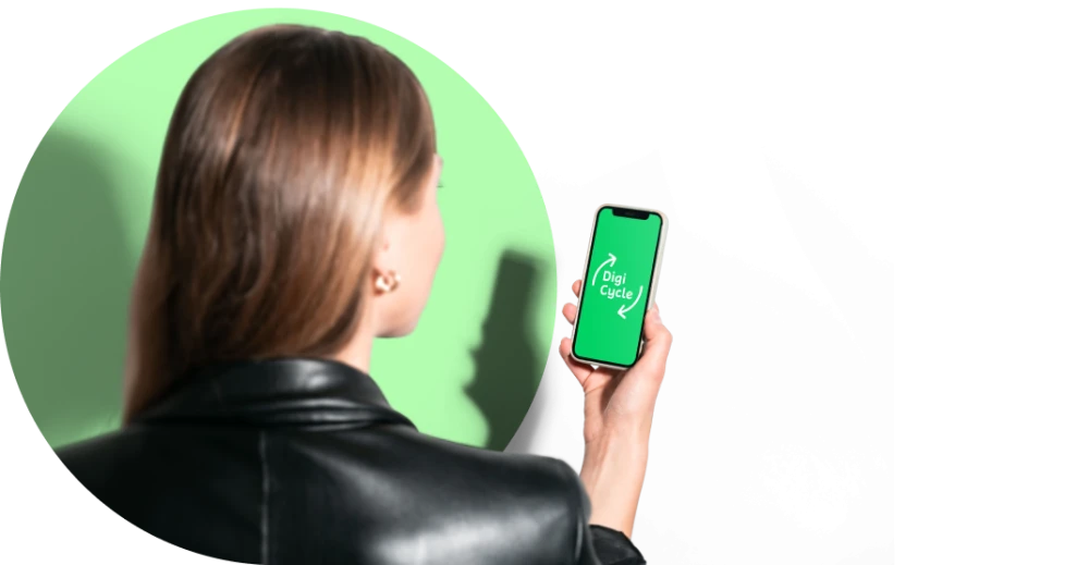 Frau mit braunen Haaren und schwarzer Lederjacke haelt Smartphone in der Hand, das die App Digi Cycle mit gruenem Bildschirm und Recycling-Symbolen anzeigt
