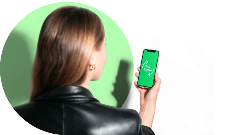 Frau mit braunen Haaren und schwarzer Lederjacke haelt Smartphone in der Hand, das die App Digi Cycle mit gruenem Bildschirm und Recycling-Symbolen anzeigt