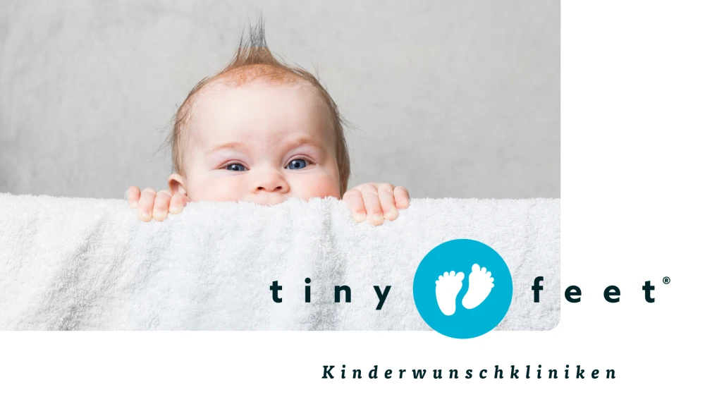Baby schaut ueber eine Decke, Tiny Feet Kinderwunschkliniken Logo mit zwei kleinen Fueßen auf blauem Hintergrund, Fruchtbarkeitsbehandlung und Kinderwunschzentrum