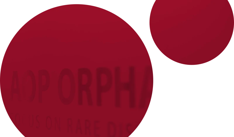 Zwei ueberlappende rote Kreise, die einen Teil eines Schriftzugs verdecken, der AOP ORPHAN zeigt.