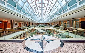 Modernes, lichtdurchflutetes Atrium eines Hotels in Wien mit glaeserner Kuppeldecke, im Vordergrund kunstvolles Mosaik im Bodenbelag