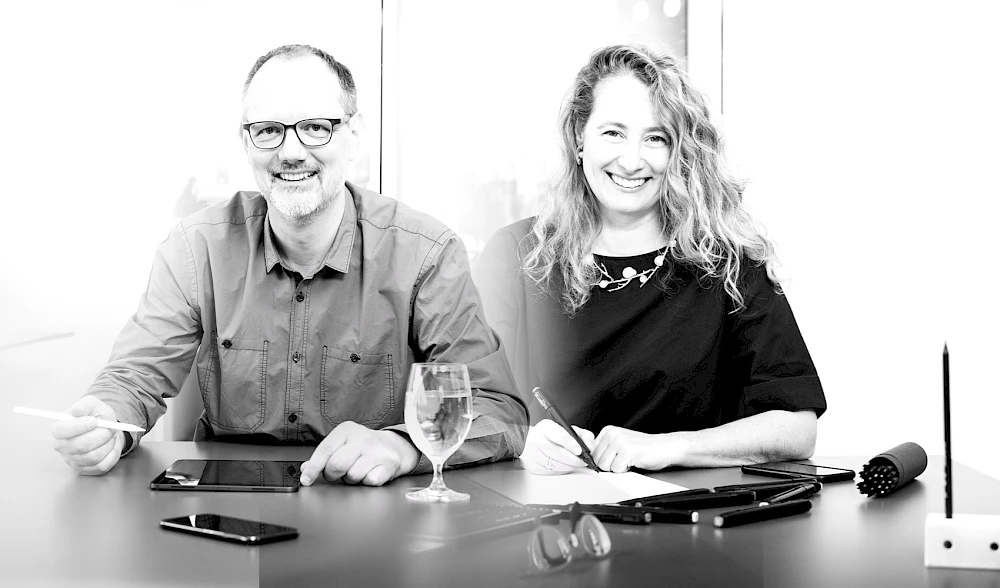Zwei Fachleute im kreativen Arbeitsprozess – Zusammenarbeit mit digitalen Tools und handschriftlichen Notizen
