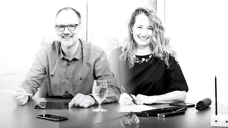 Zwei Fachleute im kreativen Arbeitsprozess – Zusammenarbeit mit digitalen Tools und handschriftlichen Notizen