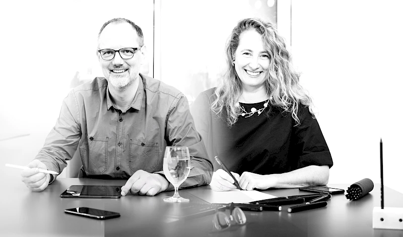 Zwei Fachleute im kreativen Arbeitsprozess – Zusammenarbeit mit digitalen Tools und handschriftlichen Notizen