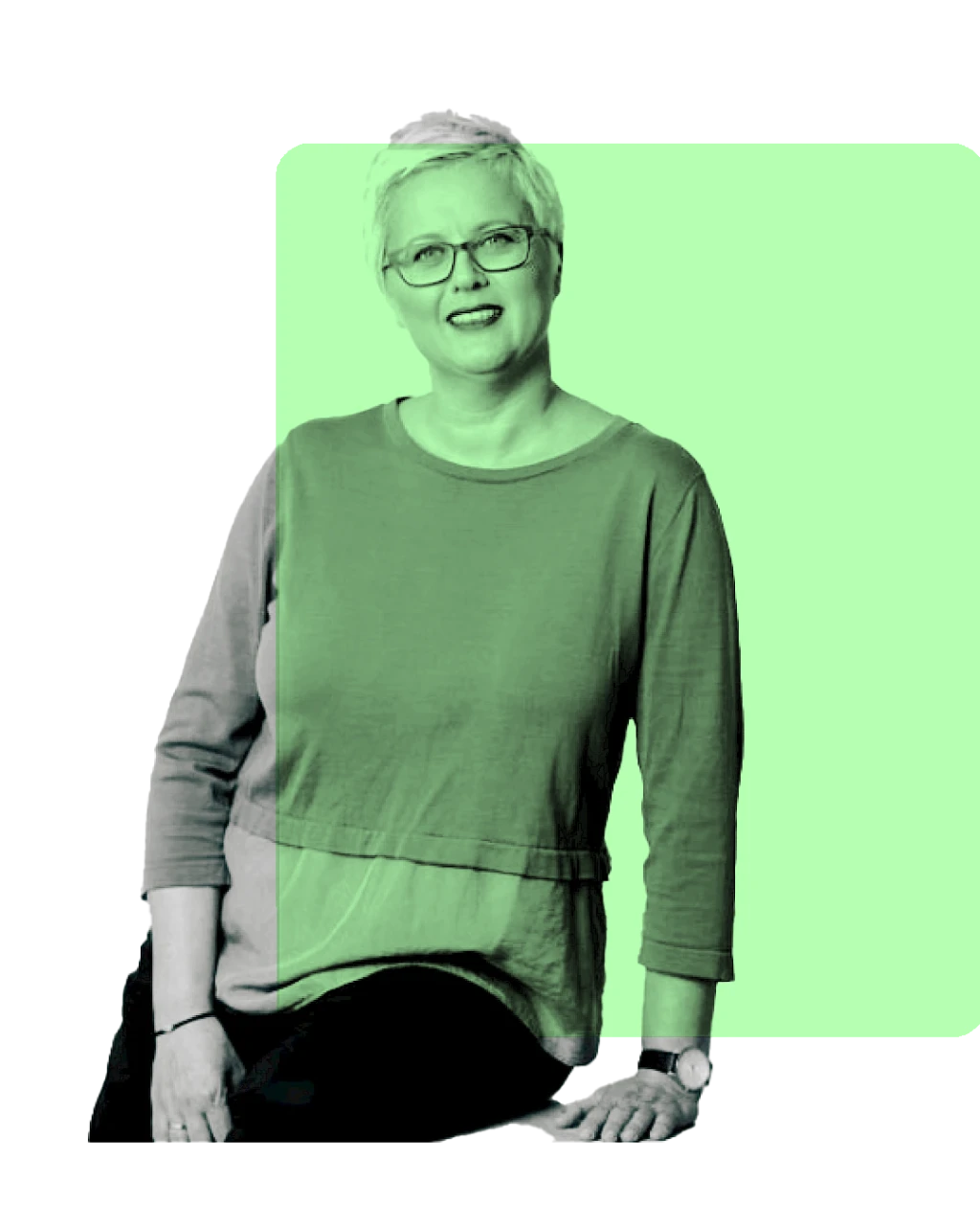 Frau mit kurzen Haaren und Brille lehnt sich an Tisch an