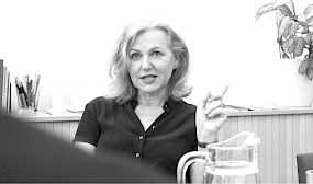 Frau sitzt bei Tisch mit Wasserkrug