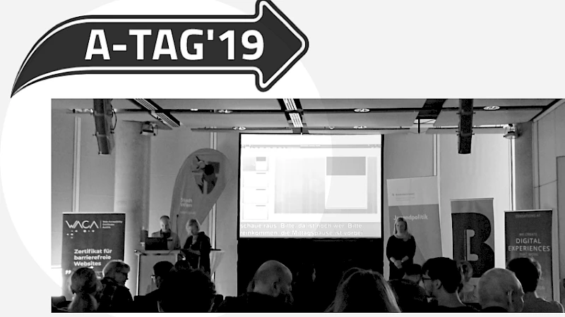 Logo des A-Tags und Ansicht des Praesentationsraums mit Publikum und Buehne.