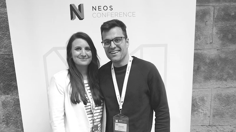 Frau und Mann posieren fuer Foto vor Fotowand auf der NEOS Conference in Dresden