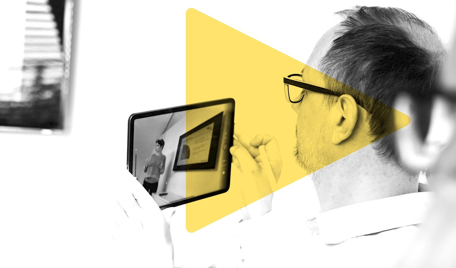 Mann mit Brille beim konzentrierten Ansehen eines Videos auf seinem iPad