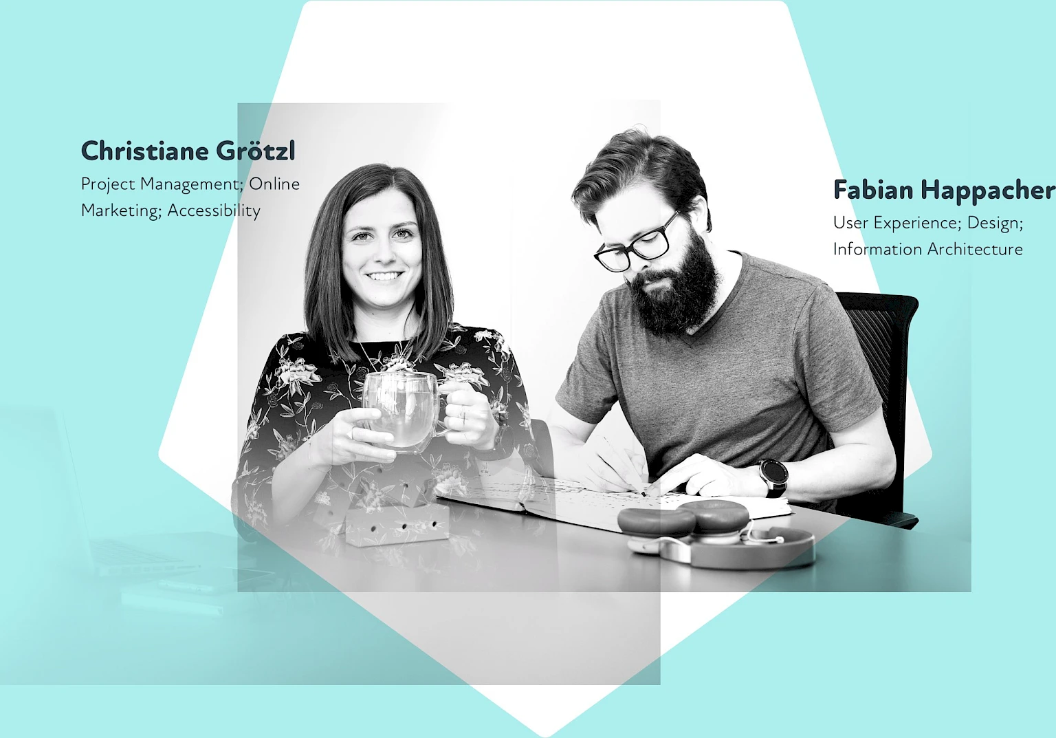 Frau haelt lachelnd Tasse, Mann mit Brille und Bart abreitet konzentriert an Designprojekt