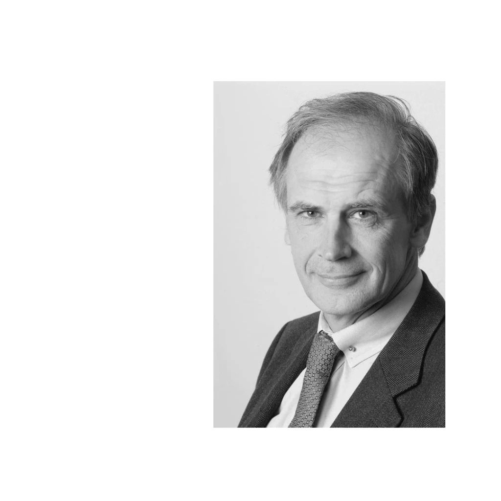 Portrait eines älteren Mannes im Anzug und Krawatte, mit grauen Haaren und leichtem Lächeln.