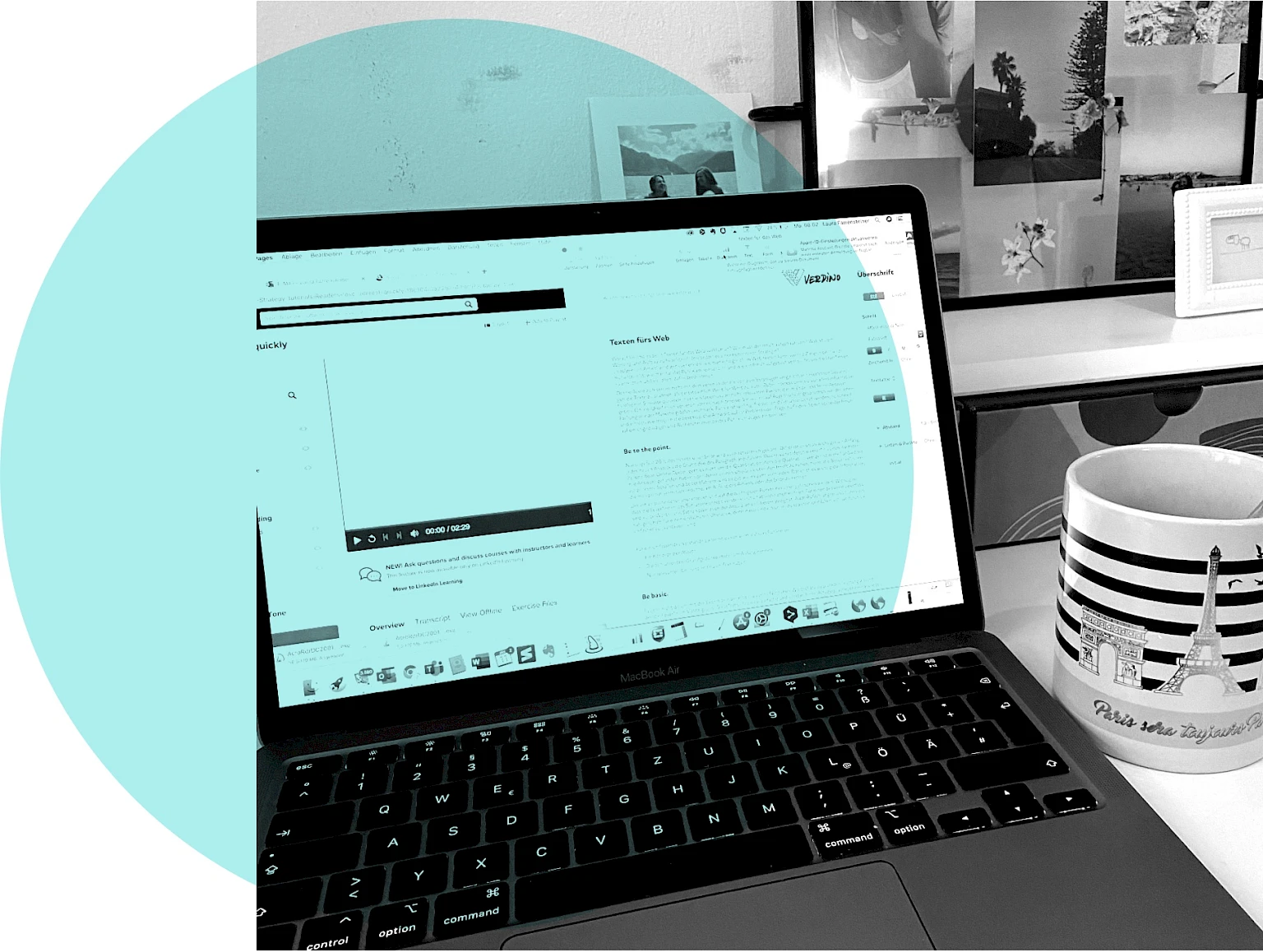Laptop neben Tasse und Bilderrahmen