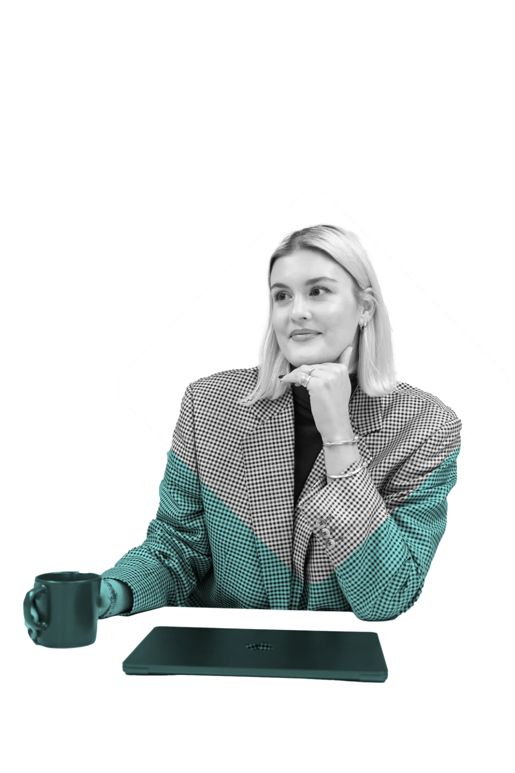 Eine Frau sitzt am Tisch mit Tasse und Laptop, blickt ruhig und konzentriert zur Seite.